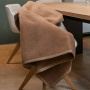 Couverture douillette en marron clair présentée sur une chaise