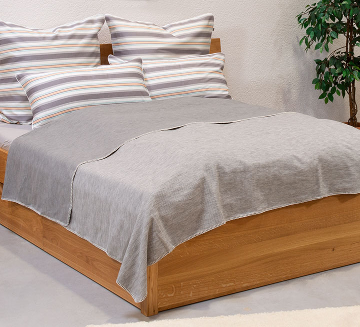 Dessus-de-lit réversible sur un lit en coloris gris et dimension 220x250 cm